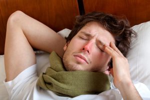 Mann liegt mit Grippe im Bett